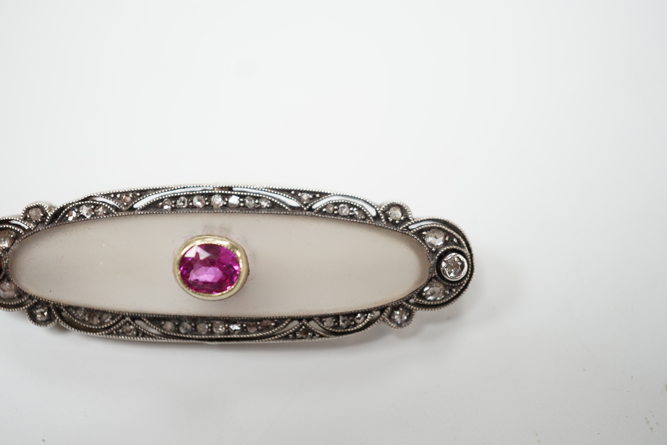 A 1920's yellow metal, diamond and single stone pink sapphire set rock crystal oval brooch, 48mm, gross weight 7.7 grams. Good condition.